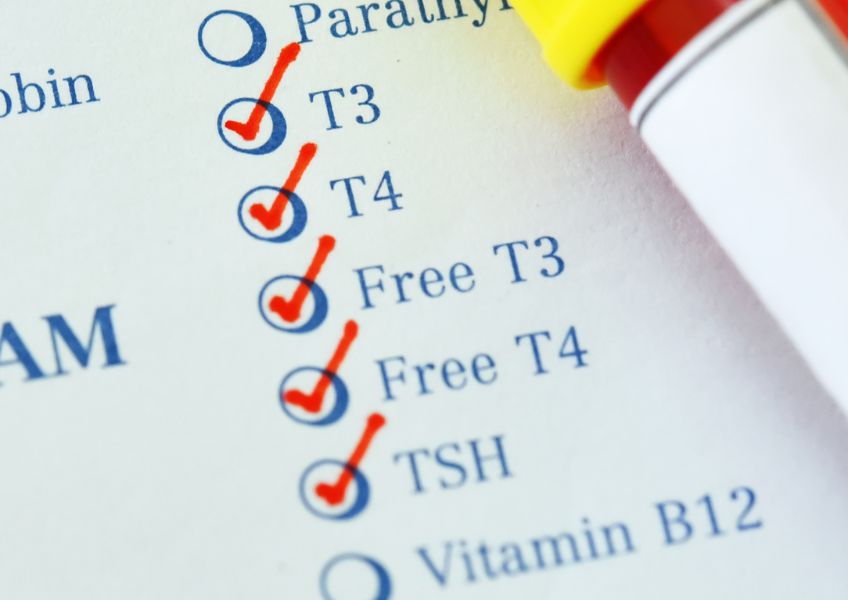 Lista de exames de sangue, com um tubo de coleta em cima da folha.