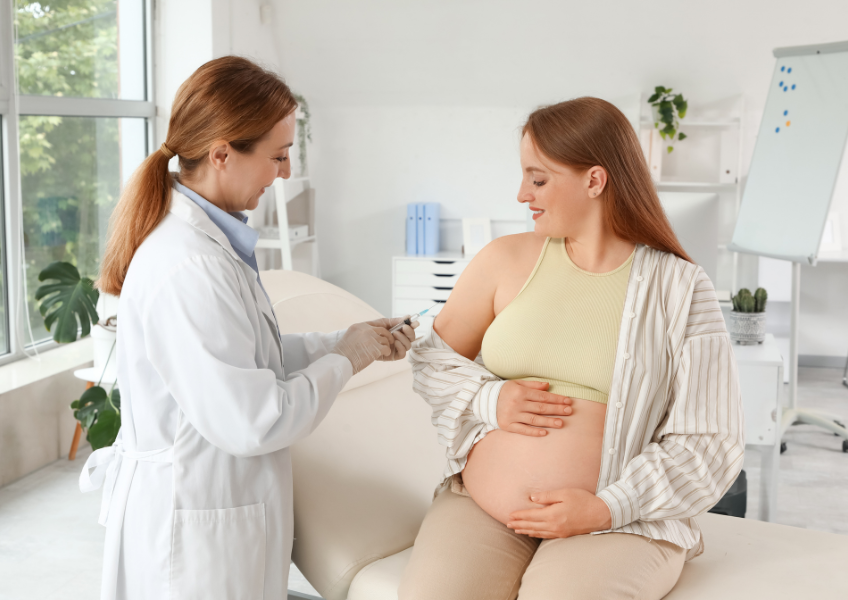 Gestante está no consultório médico tomando vacina.